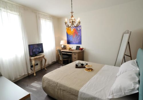 Camera Ornella Superiore a La Finestra sul porto di Cesenatico con letto, scrivania, TV e lussuoso lampadario