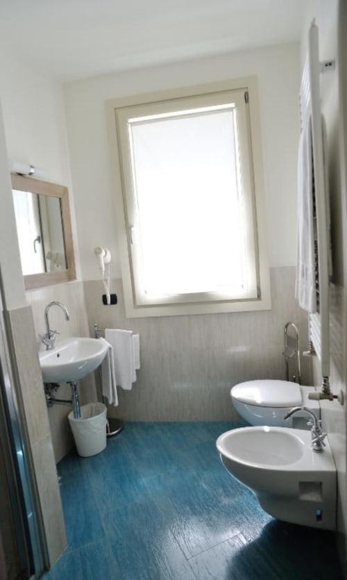 Bagno moderno nella Superior Ornella Room di La Finestra sul porto, Cesenatico con doppio lavabo, bidet, WC e finestra con