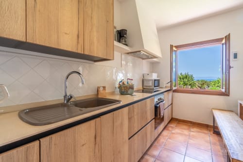 Cocina moderna con muebles de madera y vistas al mar en la villa Can Jaumí, Artá, Bahía de Alcúdia