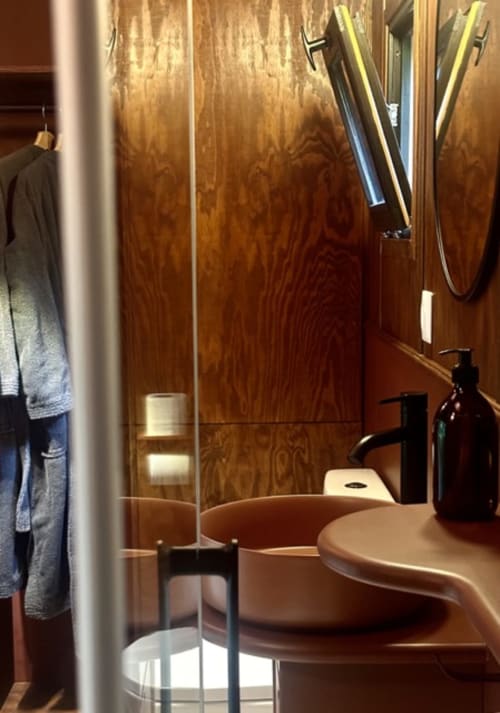 Salle de bains moderne avec carrelage imitation bois et vasque épurée au gîte Micro Palaces à Vaulx