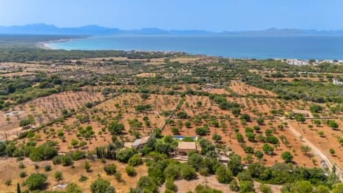 Vista aérea de la villa Can Jaumí en Artá con olivares, Bahía de Alcúdia y Mar Mediterráneo