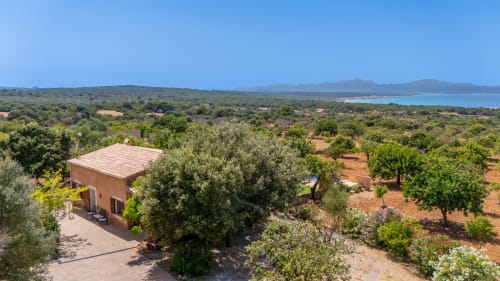 Villa de terracota moderna rodeada de olivares con vistas a la bahía turquesa en Artà, Mallorca