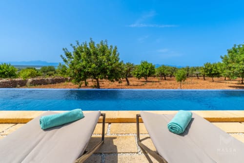 Lujosas tumbonas de piscina con vistas a huerta mediterránea en Massa Properties Artà, España