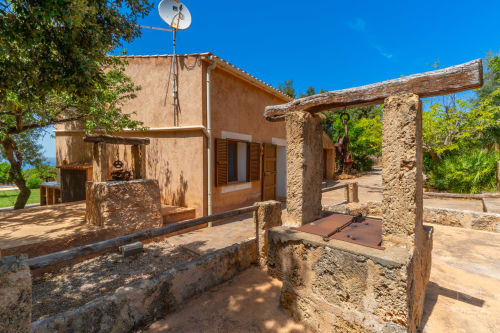 Patio rústico de piedra con edificios de terracota en Massa Properties, Artà, España