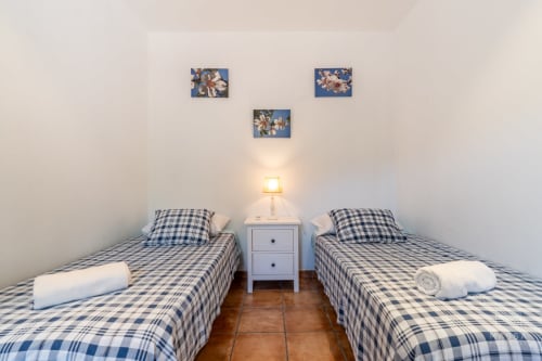 Habitación doble con ropa de cama a cuadros azules en Massa Properties, Artà, España
