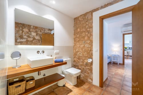 Baño moderno en Massa Properties de Artà con paredes de piedra, lavabo de cerámica y suelos de terracota