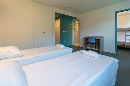 Chambre moderne à la Maison Du Haut Salat à Seix avec deux lits, accents turquoise et salle de bain privée