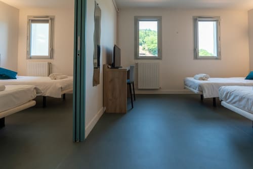 Chambre quadruple Maison Du Haut Salat avec lits jumeaux, sol bleu, fenêtres sur rivière et salle de bains partagée