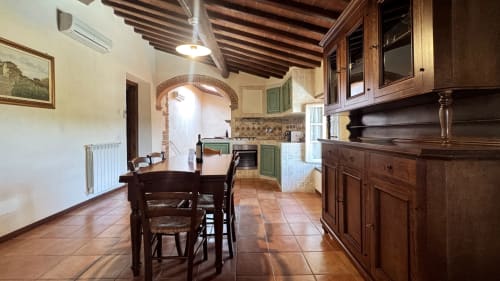 Spacious family apartment kitchen and dining area at Borgo di Erboli in Cavriglia with wooden beams and rustic charm