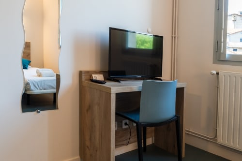 Bureau moderne de chambre d'hôtel avec téléviseur écran plat et chaise bleue à la Maison Du Haut Salat à Seix, France