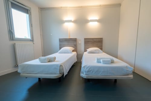 Chambre twin moderne à la Maison Du Haut Salat à Seix avec deux lits simples, têtes de lit en bois et éclairage contemporain