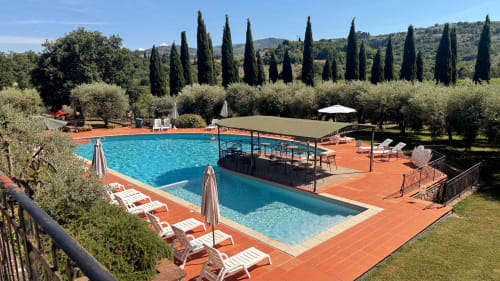 Swimming pools at Borgo di Erboli B&B in Cavriglia, Italy, surrounded by cypress trees and olive groves