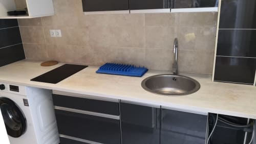 Cocina privada en habitación del Hostal Porto Mar Salou con fregadero, placa de cocción y escurreplatos azul