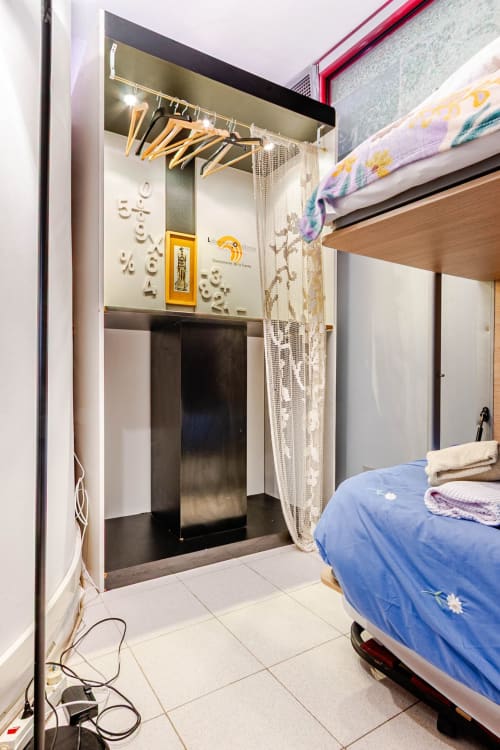 Dormitorio del apartamento de Tessa en Matadepera con cama, altar, estanterías de madera y entrada al baño moderno
