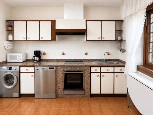 Cocina moderna de la villa Vila Mar de Lua, Oia, con electrodomésticos de acero inoxidable y encimeras de corcho