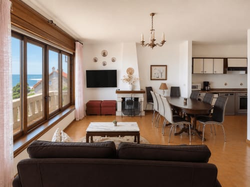 Villa espaciosa con vistas al mar en Oia, sala abierta, comedor, cocina, chimenea y vistas al océano desde el balcón
