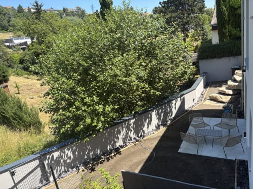Vue sur le jardin depuis la terrasse de l'appartement Résidence Les 3 Volcans à Clermont-Ferrand avec espace détente