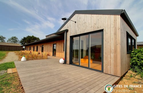 Cottage en bois moderne avec terrasse aux écuries du bout du monde, Landunvez, grandes fenêtres et vue sur le jardin