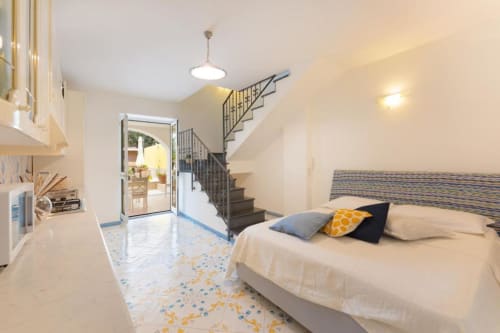 Camera luminosa della mansarda a IL POETA a Procida con cucina, scala e vista sul giardino