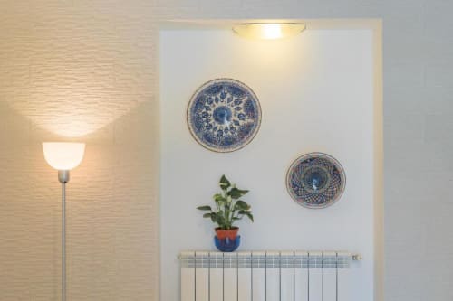 Appartamento con vista giardino presso Il Poeta B&B a Procida, con piatti blu decorativi e pianta in vaso sopra il radiatore