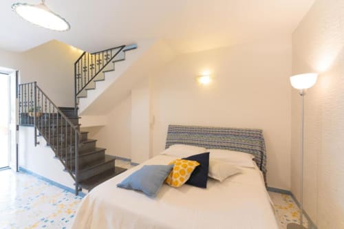 Camera da letto luminosa della maisonette a IL POETA a Procida con letto, scala e illuminazione moderna