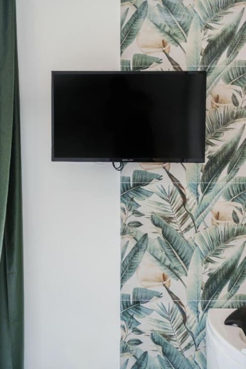 Televisore a schermo piatto su carta da parati botanica nella Camera Reale del boutique hotel IL POETA, Procida