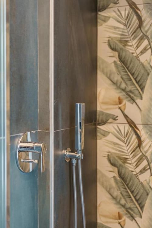 Doccia moderna con soffione portatile e rubinetteria a parete presso l'hotel IL POETA Procida, piastrelle botaniche visibili