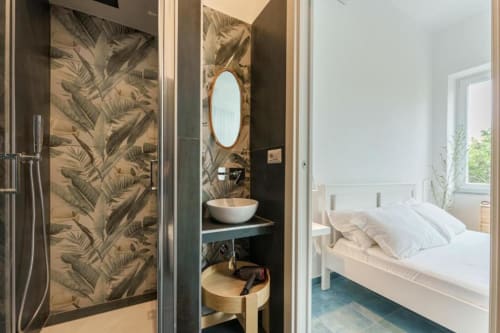 Bagno en-suite moderno con piastrelle tropicali e specchio rotondo collegato alla camera da letto presso IL POETA, Procida