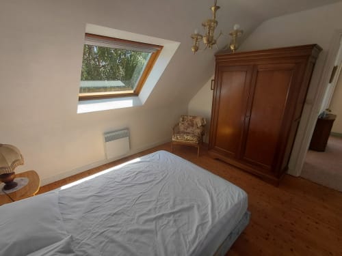 Chambre mansardée lumineuse avec verrière, armoire en bois et vue sur le jardin à la Maison Lannivrec, Belle Île en Mer