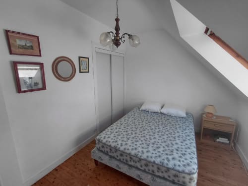 Chambre douillette sous les toits du gîte Maison Lannivrec à Locmaria Belle-Île, avec literie à motifs bleus et mobilier rustique en bois
