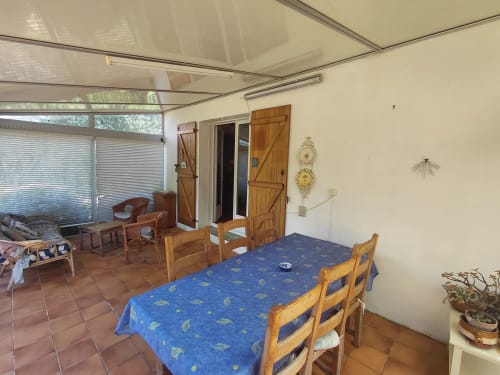 Salle à manger du gîte Maison Lannivrec à Locmaria, Belle Île en Mer, avec chaises en bois et nappe bleue dominant la vue