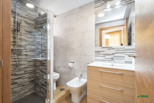 Modern bathroom at Apartamentos Manbea in Almería with walk-in shower, wooden vanity and mirror