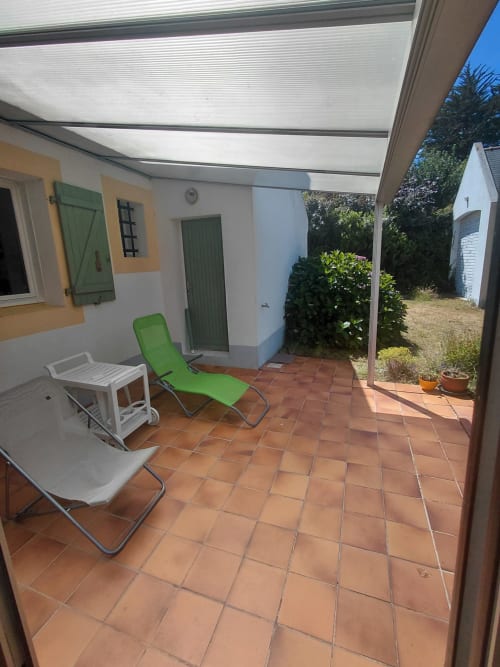 Patio couvert de la maison d'hôtes Lannivrec à Locmaria, Belle Île avec chaises longues et carrelage en terre cuite