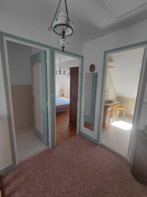 Couloir central du gîte Maison Lannivrec à Locmaria avec portes turquoise menant aux chambres et salle de bain