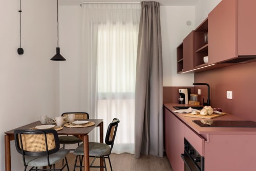 Studio moderno presso Dimora Silva Nature Suites con cucina in terracotta, tavolo da pranzo, lampade a sospensione e porte in vetro