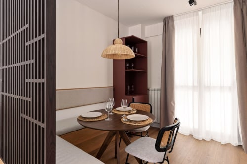 Moderna zona pranzo a Dimora Silva Nature Suites con tavolo rotondo, lampada a sospensione intrecciata e arredi contemporanei