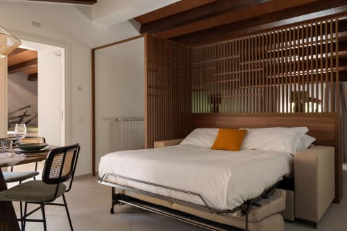 Modern bedroom at Dimora Silva Nature Suites with Murphy bed, wood canopy, desk, and minimalist decor in San Martino delle