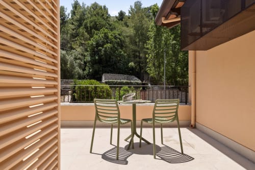 Modern balcony at Dimora Silva Nature Suites with green chairs, wooden screens, and forest views in San Martino delle Scale