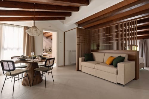 Dimora Silva Nature Suites suite with wooden beams, beige sofa, dining area, and modern furnishings in San Martino delle