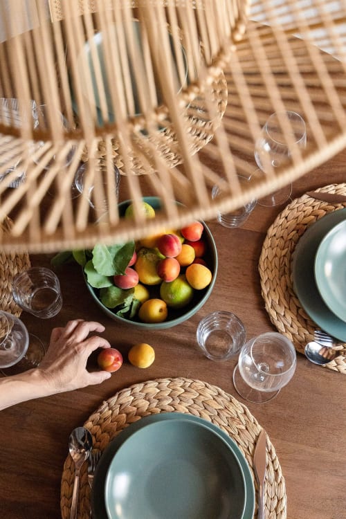 Elegant table setting at Dimora Silva Nature Suites with fresh fruits, straw placemats, and sage green plates in San Martino