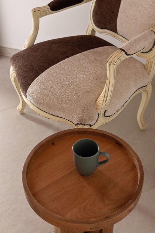 Cream upholstered armchair with wooden table and mug at Dimora Silva Nature Suites