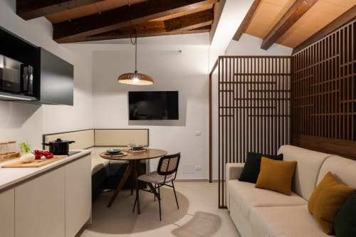 Moderno appartamento presso Dimora Silva Nature Suites con cucina, zona living, divano beige, travi in legno e TV a San Martino