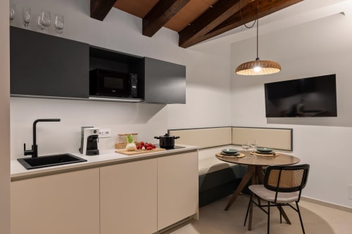 Cucina e zona pranzo moderne nell'appartamento Dimora Silva 6 con mobili beige, travi in legno e angolo colazione
