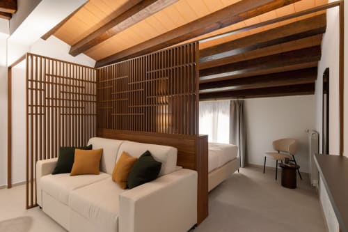 Camera da letto Dimora Silva Nature Suites con travi in legno, letto a baldacchino, divano color crema e arredi moderni a San Martino