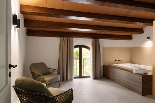 Bagno dell'appartamento Dimora Silva 6 con travi in legno, vasca da bagno, lettini e arcata presso Nature Suites