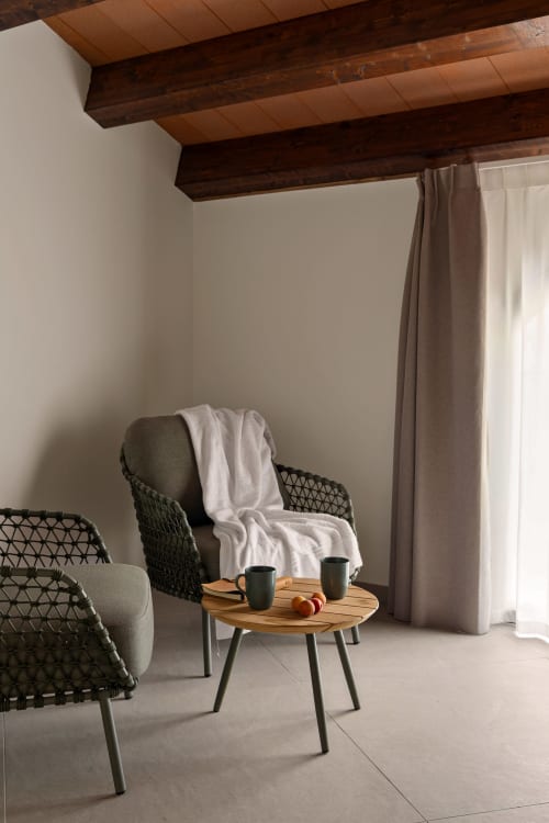 Accogliente zona salotto a Dimora Silva Nature Suites con sedie intrecciate, tavolo in legno e vista della camera San Martino delle Scale