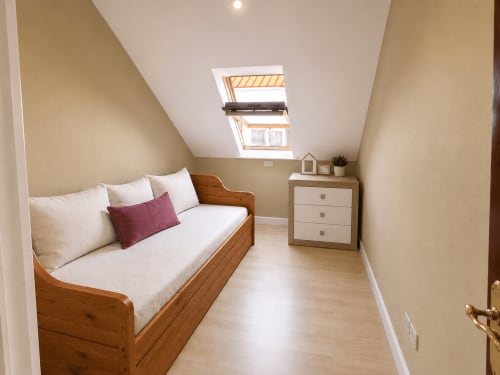 Acogedora habitación bajo techo en Holibai, Baiona, con cama de madera, tragaluz y mobiliario moderno