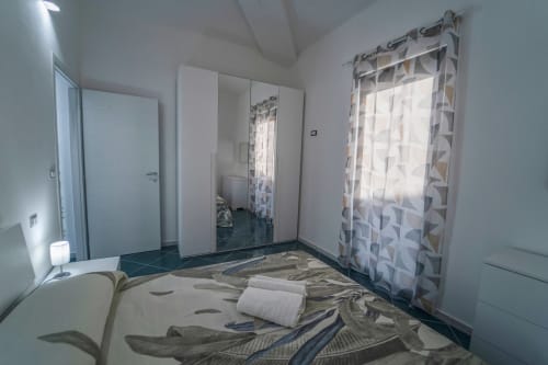 Camera moderna dell'Antico Palazzo del Corso a Mirto Crosia con letto, armadio, finestra e climatizzazione