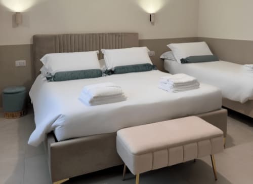 Camera da letto deluxe di Maison ì Room a Reggio Calabria con letti gemelli, biancheria bianca e cuscini d'accento verdi