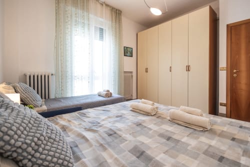 Spaziosissima camera da letto nell'appartamento AmazHome a Rimini con letti gemelli, armadio in legno e vista sulla città